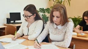 De studenten bestuderen in het klaslokaal bij de schoolbank stock foto De studenten bestuderen in het klaslokaal bij de schoolbank stock foto