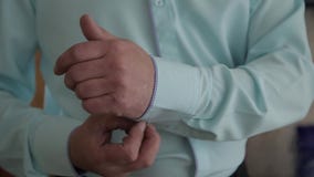 De succesvolle mens in het blauwe kostuum maakt zijn kokers, close-up recht stock footage De succesvolle mens in het blauwe kostuum maakt zijn kokers, close-up recht stock footage