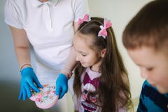 De tandarts geeft een stuk speelgoed voor weinig geduldig, krijgen de gelukkige kinderen een heden royalty-vrije stock afbeeldingen De tandarts geeft een stuk speelgoed voor weinig geduldig, krijgen de gelukkige kinderen een heden royalty-vrije stock afbeeldingen