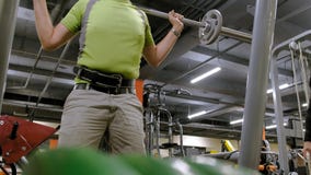 De te zware man doet hurkzit met hurkzit met een gewichtsschijf voor een barbell De mens van de geschiktheid training Gezond leve stock video De te zware man doet hurkzit met hurkzit met een gewichtsschijf voor een barbell De mens van de geschiktheid training Gezond leve stock video