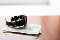 De tijd is geld Honderd dollars en zwart horloge op houten lijst royalty-vrije stock afbeelding De tijd is geld Honderd dollars en zwart horloge op houten lijst royalty-vrije stock afbeelding