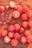 De tomaten van de besnoeiingsdruif op houten scherpe raad Stock Afbeeldingen De tomaten van de besnoeiingsdruif op houten scherpe raad Stock Afbeeldingen