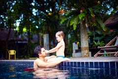 De vader en de zoon genieten van ontspannend in de pool bij stille ontsnapping stock foto's De vader en de zoon genieten van ontspannend in de pool bij stille ontsnapping stock foto's