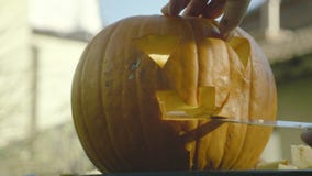 De vader snijdt met het griezelige hoofd van messenhalloween De mensen` s handen snijden mes de pompoen griezelige mond met tande stock videobeelden De vader snijdt met het griezelige hoofd van messenhalloween De mensen` s handen snijden mes de pompoen griezelige mond met tande stock videobeelden