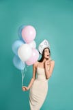 De verbaasde ballon van de vrouwenholding en giftdoos over grijze achtergrond het bekijken camera royalty-vrije stock afbeeldingen De verbaasde ballon van de vrouwenholding en giftdoos over grijze achtergrond het bekijken camera royalty-vrije stock afbeeldingen