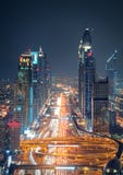 De verbazende horizon van de binnenstad en de weg die van nachtdoubai tot Abu Dhabi, Doubai, Verenigde Arabische Emiraten leiden stock fotografie De verbazende horizon van de binnenstad en de weg die van nachtdoubai tot Abu Dhabi, Doubai, Verenigde Arabische Emiraten leiden stock fotografie