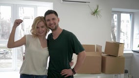 De verhuizing aan nieuw huis, portret van het glimlachen van minnaarskerel met meisje toont sleutels aan flat en omhelzing terwij stock video De verhuizing aan nieuw huis, portret van het glimlachen van minnaarskerel met meisje toont sleutels aan flat en omhelzing terwij stock video