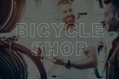 De verkoper in fietswinkel helpt een koper band kiezen royalty-vrije stock fotografie De verkoper in fietswinkel helpt een koper band kiezen royalty-vrije stock fotografie