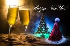 De vieringsachtergrond van de nieuwjaarvooravond met paar van fluiten en fles champagne met Kerstmisattributen (of elementen) op stock afbeeldingen De vieringsachtergrond van de nieuwjaarvooravond met paar van fluiten en fles champagne met Kerstmisattributen (of elementen) op stock afbeeldingen