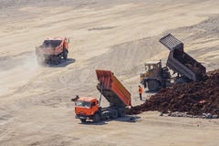 De vrachtwagens bij de bodem van de kuil maken de grond leeg stock afbeeldingen De vrachtwagens bij de bodem van de kuil maken de grond leeg stock afbeeldingen