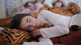De vrienden vermoeiden na de partij, die samen op het bed slapen stock video De vrienden vermoeiden na de partij, die samen op het bed slapen stock video