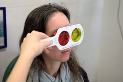 De vrij jonge de oftalmoloogopticien van de vrouwenoptometrist voert een kleurenblindheidstest uit stock afbeelding De vrij jonge de oftalmoloogopticien van de vrouwenoptometrist voert een kleurenblindheidstest uit stock afbeelding