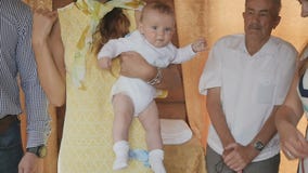 De vrouw met baby in wapens kruist zich tijdens doopselritueel in kerk stock videobeelden De vrouw met baby in wapens kruist zich tijdens doopselritueel in kerk stock videobeelden