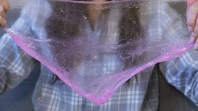 De vrouw rekt een het roze slijm en spelen uit Close-uphanden stock videobeelden De vrouw rekt een het roze slijm en spelen uit Close-uphanden stock videobeelden