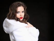 De vrouw van de manierschoonheid in witte die bontjas op zwarte studio wordt geïsoleerd Stock Foto De vrouw van de manierschoonheid in witte die bontjas op zwarte studio wordt geïsoleerd Stock Foto