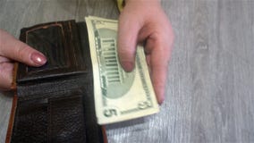 De vrouwelijke handen houden dollarrekeningen van haar beurs en zet hen terug in de beurs stock foto De vrouwelijke handen houden dollarrekeningen van haar beurs en zet hen terug in de beurs stock foto