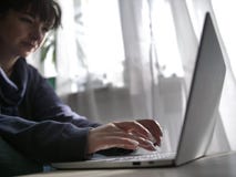 De vrouwelijke handen typen op het toetsenbord van laptop op de achtergrond van het venster royalty-vrije stock afbeeldingen De vrouwelijke handen typen op het toetsenbord van laptop op de achtergrond van het venster royalty-vrije stock afbeeldingen