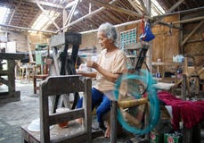 De vrouwenarbeider weeft stof in een wevende fabriek stock fotografie De vrouwenarbeider weeft stof in een wevende fabriek stock fotografie