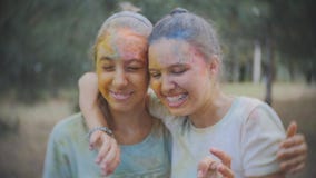 De waternevel van twee van tieners omvat in Holi-verf in het Park na Holi-festival stock video De waternevel van twee van tieners omvat in Holi-verf in het Park na Holi-festival stock video