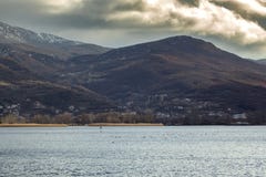 De winter bewolkte zonsondergang over Meer Ohrid met riviermeeuwen macedonië stock afbeeldingen De winter bewolkte zonsondergang over Meer Ohrid met riviermeeuwen macedonië stock afbeeldingen