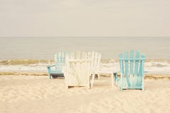 De witte en blauwe ligstoelen op zandzeegezicht en de heldere hemel in de zomervakantie ontspannen Het uitstekende filter kleuren Royalty-vrije Stock Foto's De witte en blauwe ligstoelen op zandzeegezicht en de heldere hemel in de zomervakantie ontspannen Het uitstekende filter kleuren Royalty-vrije Stock Foto's