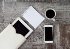 De witte tablet, de telefoon, de kop van koffie en het notitieboekje zijn op de lijst Het werk thuis freelance royalty-vrije stock afbeeldingen De witte tablet, de telefoon, de kop van koffie en het notitieboekje zijn op de lijst Het werk thuis freelance royalty-vrije stock afbeeldingen