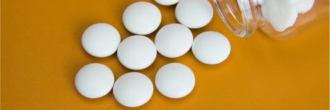 De witte tabletten zijn verspreid van een glasfles stock afbeeldingen De witte tabletten zijn verspreid van een glasfles stock afbeeldingen
