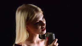 De zanger zingt in een retro microfoon Zwarte achtergrond Sluit omhoog Zachte nadruk stock video De zanger zingt in een retro microfoon Zwarte achtergrond Sluit omhoog Zachte nadruk stock video