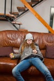 De zitting van het Teenagedmeisje op bank en eet chocolade - Lui om eender wat te doen - Ochtenden is moeilijk stock fotografie De zitting van het Teenagedmeisje op bank en eet chocolade - Lui om eender wat te doen - Ochtenden is moeilijk stock fotografie
