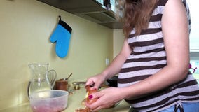 De zwangere schil van vrouwenhanden van uibol in keuken Wijfje met reusachtige buik stock footage De zwangere schil van vrouwenhanden van uibol in keuken Wijfje met reusachtige buik stock footage