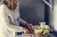 De zwangere vrouw kookt salade royalty-vrije stock fotografie De zwangere vrouw kookt salade royalty-vrije stock fotografie