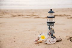 Decoración hermosa bajo la forma de faro y conchas marinas en la arena con el espacio para el texto imagen de archivo Decoración hermosa bajo la forma de faro y conchas marinas en la arena con el espacio para el texto imagen de archivo
