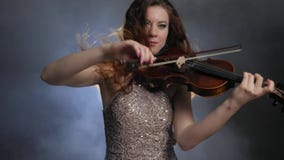 Decreto, con el fiddler largo del pelo jugando en el violín en oscuridad en humo en filarmónico almacen de metraje de vídeo Decreto, con el fiddler largo del pelo jugando en el violín en oscuridad en humo en filarmónico almacen de metraje de vídeo