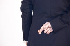 Dedos del hombre de negocios cruzados detrás el suyo detrás imagen de archivo libre de regalías Dedos del hombre de negocios cruzados detrás el suyo detrás imagen de archivo libre de regalías