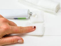 Defeated by a knife, the finger of a woman`s hand and a dressing on a white wooden table. royalty free stock photos Defeated by a knife, the finger of a woman`s hand and a dressing on a white wooden table. royalty free stock photos