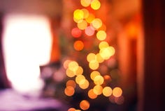 Defocused ligths of decorated Christmas tree in the rural house interior. Blurred New year festive background. royalty free stock image Defocused ligths of decorated Christmas tree in the rural house interior. Blurred New year festive background. royalty free stock image