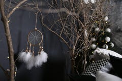 Dekor från träfilialer med ett grönt gran-träd mot bakgrunden av Dreamcatcher med vita fjädrar vit-svart kuddar arkivfoto Dekor från träfilialer med ett grönt gran-träd mot bakgrunden av Dreamcatcher med vita fjädrar vit-svart kuddar arkivfoto