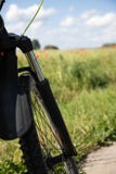 Del av framhjulet med resors mot bakgrunden av fältet för vårgräsplanråg och de röda vallmo arkivfoton Del av framhjulet med resors mot bakgrunden av fältet för vårgräsplanråg och de röda vallmo arkivfoton