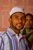 Delhi, India - September 27, 2017: Portrait of an Indian man wearing a white indian hat, looking at camera inside of the. Temple in Jama Masjid Mosque in Delhi Stock Images Delhi, India - September 27, 2017: Portrait of an Indian man wearing a white indian hat, looking at camera inside of the. Temple in Jama Masjid Mosque in Delhi Stock Images