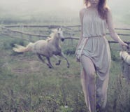 Delicate brunette posing with horse in the background royalty free stock images Delicate brunette posing with horse in the background royalty free stock images