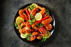 Delicious Grilled Chicken Wings With Lemon Juice And Chili Pepper On Black Concrete Background. Top View. Royalty Free Stock Image
