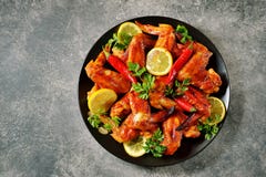 Delicious Grilled Chicken Wings With Lemon Juice And Chili Pepper On Gray Concrete Background. Top View. Copy Cpace. Stock Image Delicious Grilled Chicken Wings With Lemon Juice And Chili Pepper On Gray Concrete Background. Top View. Copy Cpace. Stock Image