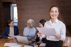 Delighted Woman Posing In Office With Documents And Colleagues Royalty Free Stock Images