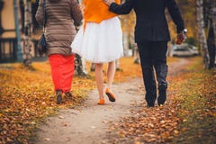 Demoiselle d'honneur, jeunes mariés marchant en parc Vue du dos Concept de mariage d'automne Photographie stock Demoiselle d'honneur, jeunes mariés marchant en parc Vue du dos Concept de mariage d'automne Photographie stock