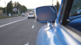 Den allvarliga manliga chauffören reflekteras i vänster sidaspegel av den rörande retro bilen Ung man som kör på en blå tappninga arkivfilmer Den allvarliga manliga chauffören reflekteras i vänster sidaspegel av den rörande retro bilen Ung man som kör på en blå tappninga arkivfilmer