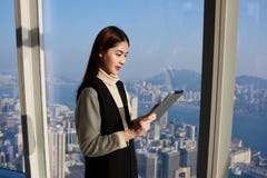 Den asiatiska kvinnliga chefen använder den digitala minnestavlan för sökande av nödvändig information fotografering för bildbyråer Den asiatiska kvinnliga chefen använder den digitala minnestavlan för sökande av nödvändig information fotografering för bildbyråer