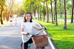 Den asiatiska lilla flickan är le, och se kameran på cykeln i utomhus- parkera, ståenden av det lyckliga gulliga barnet med cykel arkivfoton Den asiatiska lilla flickan är le, och se kameran på cykeln i utomhus- parkera, ståenden av det lyckliga gulliga barnet med cykel arkivfoton