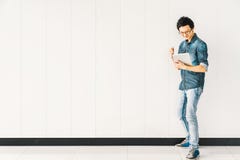 Den asiatiska mannen eller högskolestudenten som använder digitalt minnestavlabifall, firar framgång, kopieringsutrymme på vit vä royaltyfria bilder Den asiatiska mannen eller högskolestudenten som använder digitalt minnestavlabifall, firar framgång, kopieringsutrymme på vit vä royaltyfria bilder
