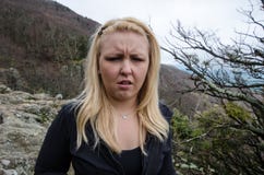 Den blonda kvinnliga fotvandraren ser sjuk och äcklad, når han har avslutat en naturvandring Ögon skelas royaltyfri fotografi Den blonda kvinnliga fotvandraren ser sjuk och äcklad, når han har avslutat en naturvandring Ögon skelas royaltyfri fotografi