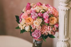 Den brud- buketten med rosa rosor och persikapioner står på bakgrund av tappningväggen royaltyfria bilder Den brud- buketten med rosa rosor och persikapioner står på bakgrund av tappningväggen royaltyfria bilder